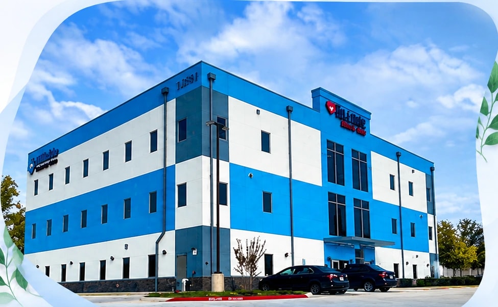 The Hillside Primary Care clinic building, a three-storey blue and white medical office under a bright sky
