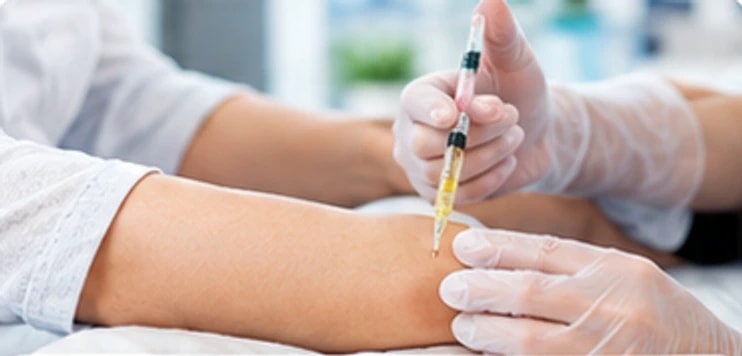 A clinician giving an injection into a patient's knee